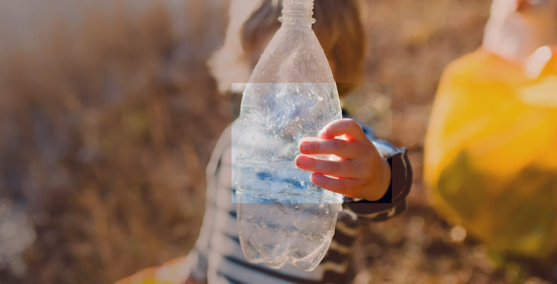 Child holding a plastic bottle