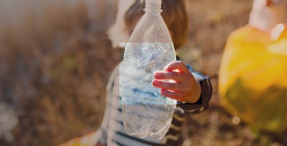 Child holding a plastic bottle